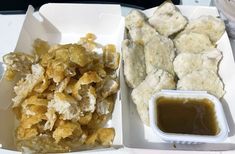 two trays filled with fried food next to dipping sauce on top of each other