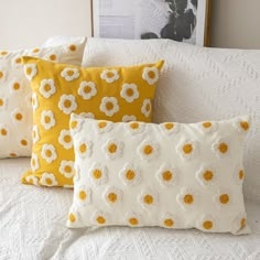 three yellow and white pillows sitting on top of a bed