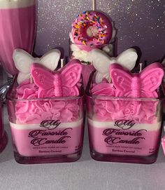 some pink candles are sitting on a table with doughnuts and sprinkles