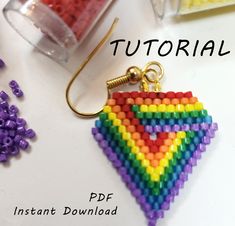 an image of a rainbow colored beaded triangle ornament on a white table