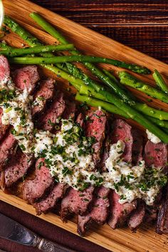 steak and asparagus on a wooden cutting board