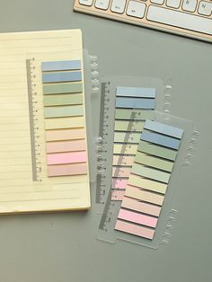 two pieces of colored paper sitting next to a keyboard