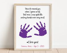 a purple handprint with the words i love you and two hands on it in front of a white wall