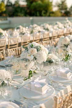 the tables are set with white flowers and place settings