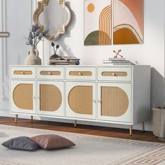 a white sideboard with wicker doors and two mirrors on the wall above it