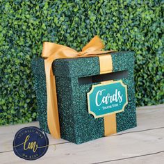 a green box with a gold ribbon and congratulations card on the front that says cards thank you