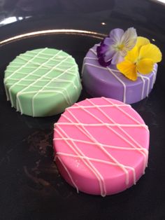 three cakes sitting on top of a black plate