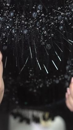 a person holding an umbrella covered in black beads