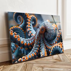 an orange and blue octopus is on the floor next to a white wall with wood floors