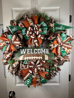 a football wreath with the words welcome on it and green, orange and white ribbons