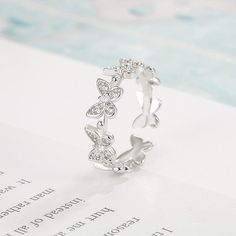 an open ring with butterflies on it sitting on top of a piece of white paper