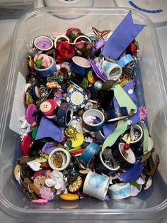 a plastic container filled with lots of different types of buttons