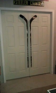 two hockey sticks are propped up against the door