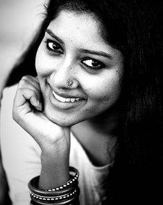 black and white photograph of a woman with piercings on her nose looking at the camera