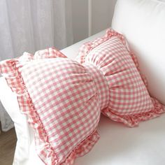 two red and white gingham pillows on a white couch