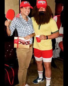 two people are dressed up in costumes and holding ping pong paddles