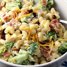 a white bowl filled with macaroni salad topped with cheese and broccoli