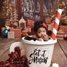 a baby sitting in a bucket with a candy cane