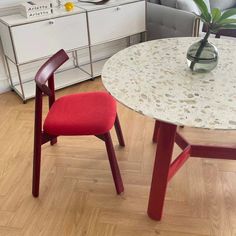 a table with two chairs and a vase on top of it next to a couch