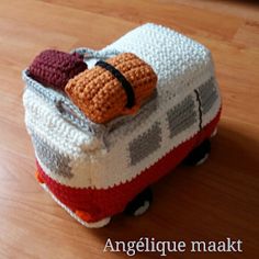 a crocheted piece of luggage sitting on top of a wooden floor