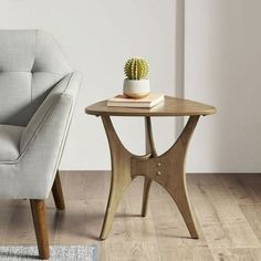 a chair and table with a cactus on it in front of a white walled wall