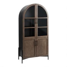 an arched wooden cabinet with glass doors on the top and bottom shelves, in front of a white background