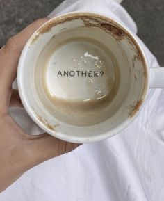 a person holding a coffee cup with the word another written on it