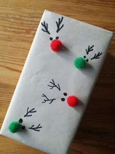 a piece of paper that has been made to look like a snowman with red and green pom - poms on it