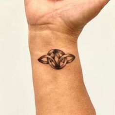 a woman's wrist tattoo with an intricate design on the left side of her arm