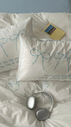 two white pillows with blue writing on them and a computer mouse laying on the pillow