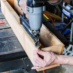 a man is using a drill to cut wood with a cordless nailer on it