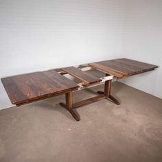 two wooden tables sitting next to each other in a room with white walls and concrete flooring