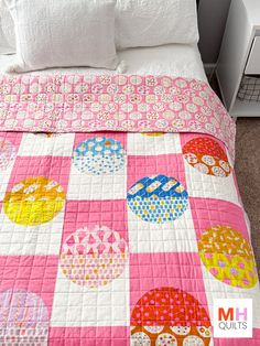 a bed with a pink and white checkered bedspread on top of it