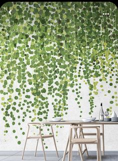 a table and chairs in front of a wall with green leaves on it