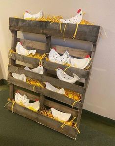 several pairs of shoes are placed on top of each other in a wooden crate that is filled with hay and straw