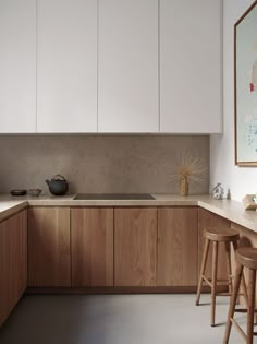 a kitchen with white cabinets and wooden stools