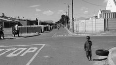 a young boy standing on the side of a road