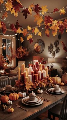 a dining room table with candles and fall leaves