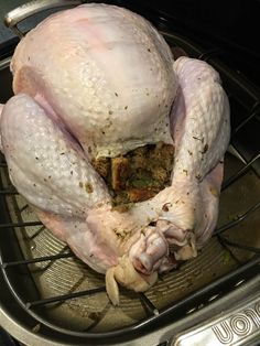 a whole turkey sitting in an oven with garlic and seasoning on it's side