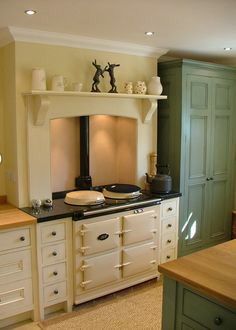 a kitchen with an old fashioned stove and green cabinetry in the backround