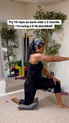 a woman sitting on the floor in front of a mirror with her leg up and arms extended