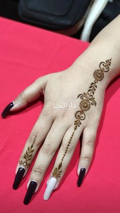 a woman's hand with henna tattoos on it