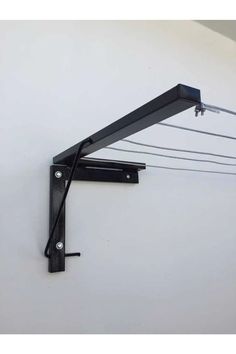 a wall mounted shelf with wires attached to the back of it and two hooks on each side