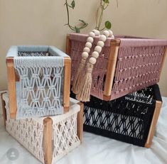 two crocheted baskets sitting next to each other on top of a white sheet