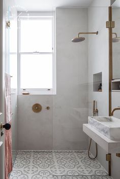 a bathroom with a window, sink and shower