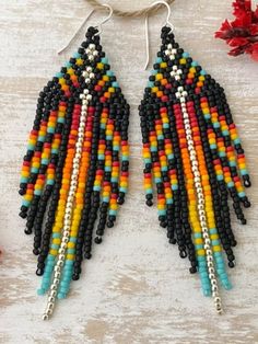 two pairs of beaded earrings on top of a table