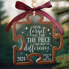 a christmas ornament with a puzzle piece hanging from it's side and the words never forget you are the piece that made the difference