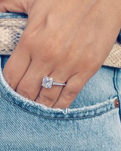 a woman's hand with a diamond ring on her finger, in jeans pocket