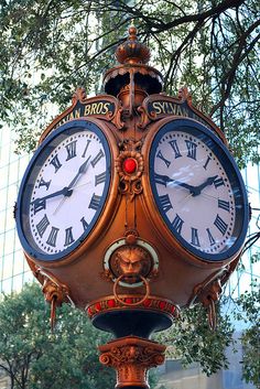 an ornate clock with roman numerals is on display in front of a building