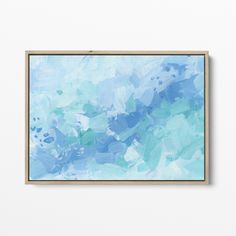 an abstract painting hangs on the wall in front of a white wall with a wooden frame